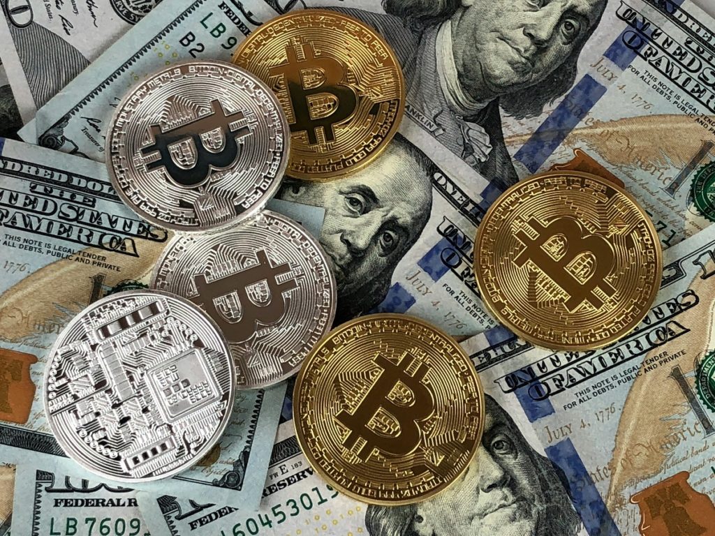 Moedas Bitcoin em cima de dólares